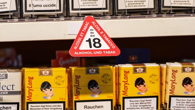 Eine Reihe Zigarette mit einem Schild: Ab 18 Eine Reihe Zigarette mit einem Schild: Ab 18