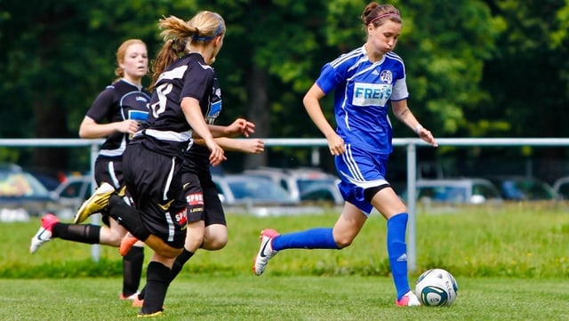 Fussballspielerin Aurelia Meier (rechts) wird von 3 Gegnerinnen verfolgt. Fussballspielerin Aurelia Meier (rechts) wird von 3 Gegnerinnen verfolgt.