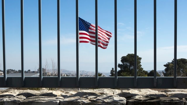 Blick durch Zaun auf US-Flagge. Blick durch Zaun auf US-Flagge.