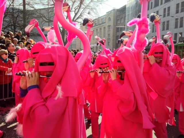 Pfeifer am Cortège mit pinken Kostümen mit Flamingoköpfen.