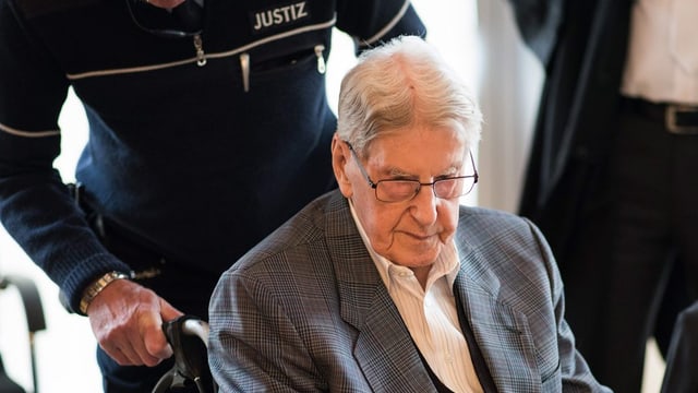 Der Angeklagte Reinhold Hanning wird im Rollstuhl an seinen Platz geschoben. Der Angeklagte Reinhold Hanning wird im Rollstuhl an seinen Platz geschoben.