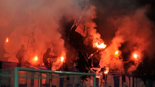 Fussballfans brennen im Stadion rote Pyrofackeln ab. Fussballfans brennen im Stadion rote Pyrofackeln ab.