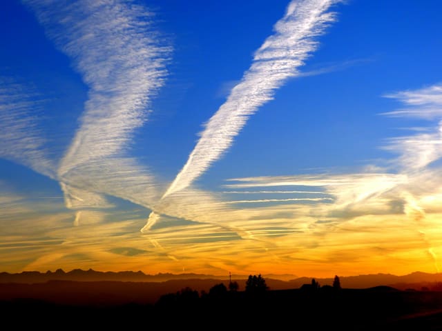 Sonnenuntergang mit Kondensstreifen am Himmel Sonnenuntergang mit Kondensstreifen am Himmel