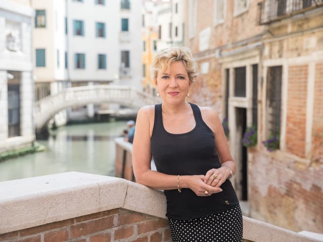 Eine Frau posiert auf einer Brücke über einen Kanal. Eine Frau posiert auf einer Brücke über einen Kanal.