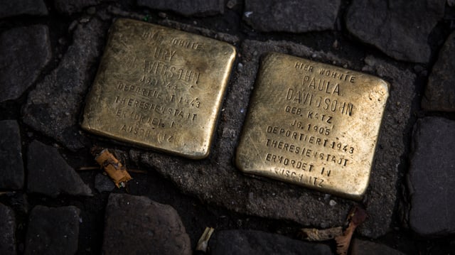 Goldene Stolpersteine zwischen Pflastersteinen Goldene Stolpersteine zwischen Pflastersteinen