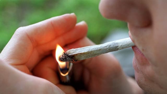 Joint wird mit Feuerzeug angezündet. Joint wird mit Feuerzeug angezündet.