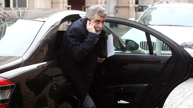 Hassan Tajik steigt telefonierend aus einem Auto Hassan Tajik steigt telefonierend aus einem Auto