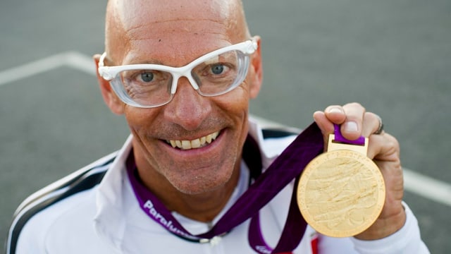 Mann mit Glatze, Sportbrille und Goldmedallie. Mann mit Glatze, Sportbrille und Goldmedallie.