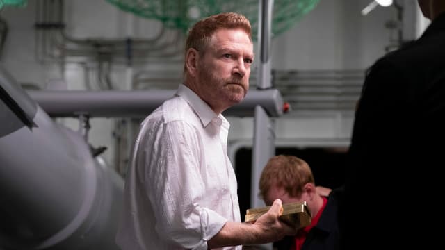 Szene: Andrei Sator (Kenneth Branagh) hält zwei Goldbarren. Szene: Andrei Sator (Kenneth Branagh) hält zwei Goldbarren.