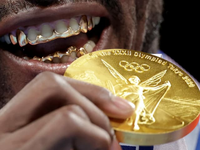Der kubanische Boxer Julio Cesar La Cruz beisst auf seine Goldmedaille, die er im Schwergewicht gewonnen hat.