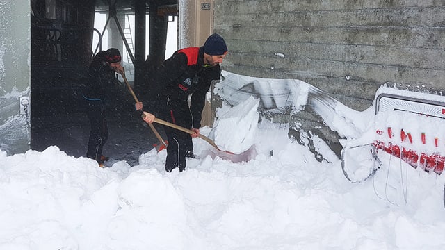 Zwei Männer schaufeln Schnee Zwei Männer schaufeln Schnee
