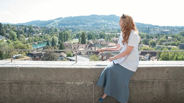 eine Frau mit Arztkittel sitzt und schaut sich die Aussicht an eine Frau mit Arztkittel sitzt und schaut sich die Aussicht an