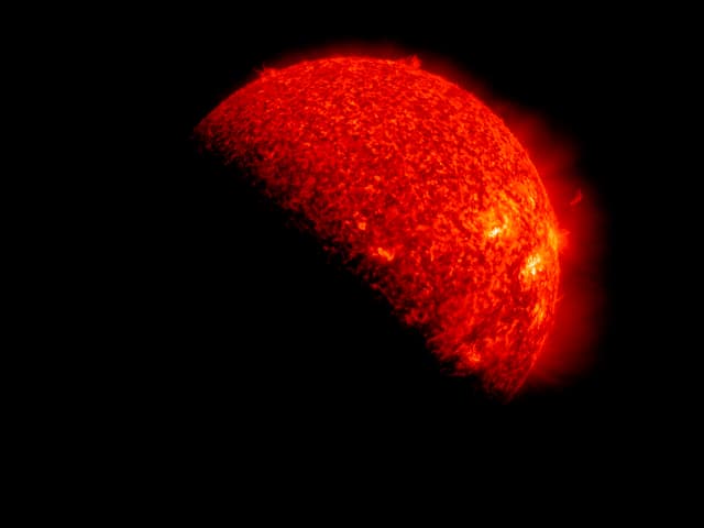 Im unteren linke Bildhälfte ist schwarz und zeigt die Erdkugel. Dahinter leuchtet die Sonne als glühende Kugel mit grossen Explosionen darauf. Im unteren linke Bildhälfte ist schwarz und zeigt die Erdkugel. Dahinter leuchtet die Sonne als glühende Kugel mit grossen Explosionen darauf.