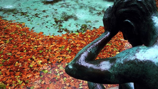 Statue die den Kopf in den Händen vergräbt Statue die den Kopf in den Händen vergräbt