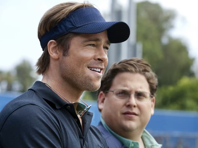 Brad Spitt steht mit einem Baseball-Cap neben Jonah Hill. Brad Spitt steht mit einem Baseball-Cap neben Jonah Hill.