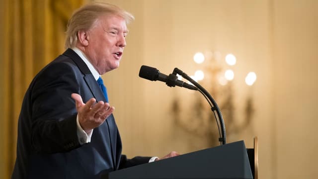 Trump spricht in ein Mikrofon. Trump spricht in ein Mikrofon.