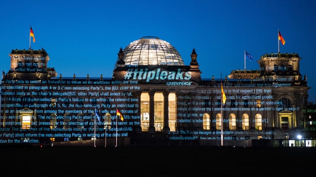Reichstagsgebäude in Berlin am frühen Morgen – mit darauf projizierten Schriftzügen. Reichstagsgebäude in Berlin am frühen Morgen – mit darauf projizierten Schriftzügen.