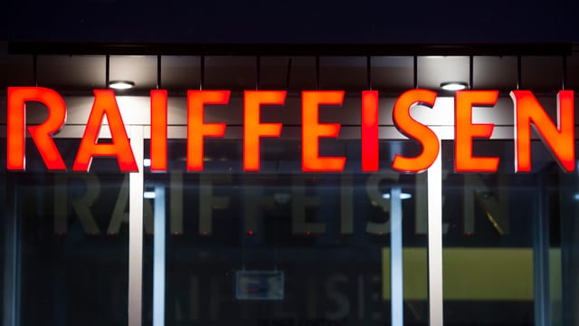Oranges Raiffeisen-Logo über dem Eingang zu einer Filiale Oranges Raiffeisen-Logo über dem Eingang zu einer Filiale