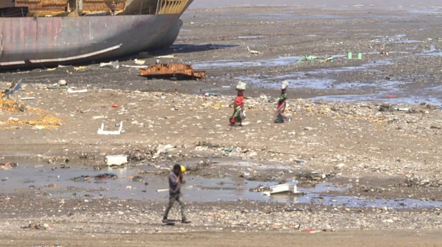 Menschen an einem verseuchten Strand. Zwei Frauen tragen Saris. Menschen an einem verseuchten Strand. Zwei Frauen tragen Saris.