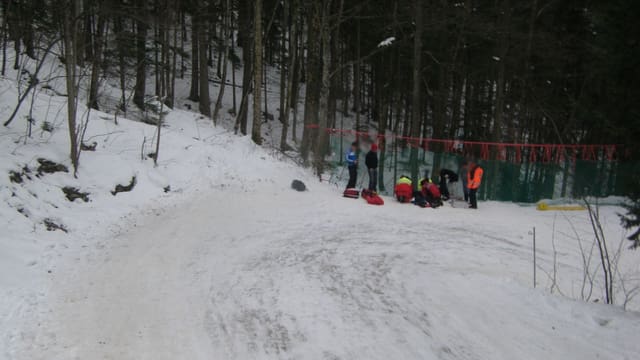 Ein verletzter Schlittelfahrer wird von Sanitätern betreut Ein verletzter Schlittelfahrer wird von Sanitätern betreut
