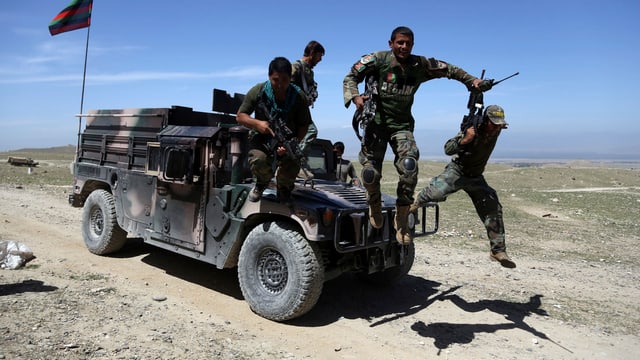 Afghanische Soldaten springen von einem Geländewagen. Afghanische Soldaten springen von einem Geländewagen.