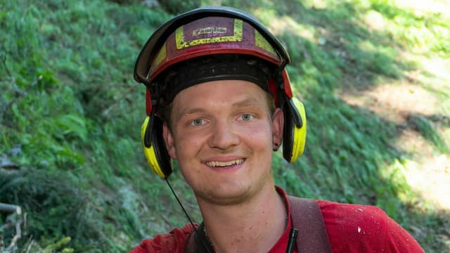 Junger Mann mit Helm im Wald Junger Mann mit Helm im Wald