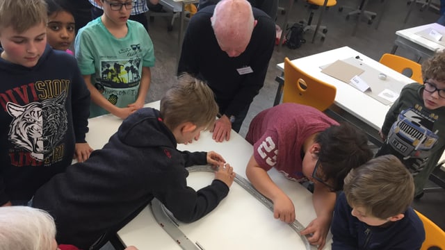 Kinder stehen um einen Tisch Kinder stehen um einen Tisch