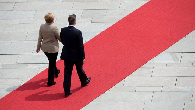 Merkel und Cameron schreiten auf dem roten Teppich. Merkel und Cameron schreiten auf dem roten Teppich.