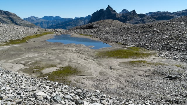 Eine alpine Landschaft mit einem kleinen Bergsee.