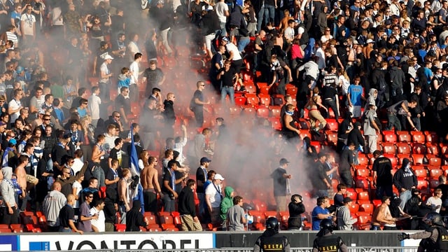 Fans geraten in einem Fussballstadion aneinander. Fans geraten in einem Fussballstadion aneinander.