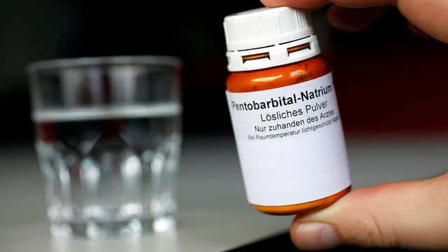 Fläschchen mit Pentobarbital-Natrium, im Hintergrund steht ein Wasserglas Fläschchen mit Pentobarbital-Natrium, im Hintergrund steht ein Wasserglas