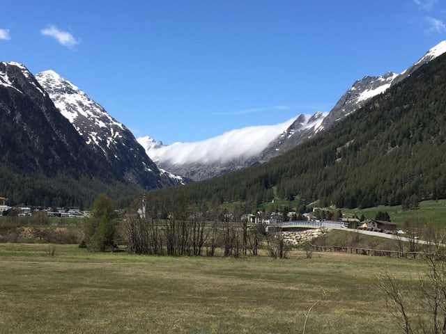 Ein Blick ins Val Bever. Auf der rechten Bergflanke liegen zähe Wolken, die von der Gegenseite der Berge rübergedrückt werden.