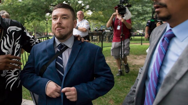 Der Anführer der weissen Rassisten, Jason Kessler (M) verlässt den Lafayette-Park nach Kundgebungsende. Der Anführer der weissen Rassisten, Jason Kessler (M) verlässt den Lafayette-Park nach Kundgebungsende.