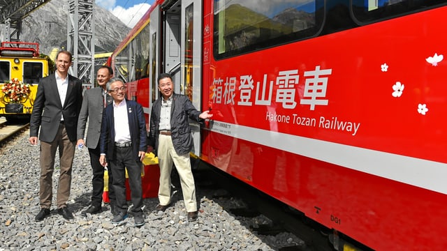 Il directur da la viafier retica Renato Fasciati, il president Stefan Engler e dus represchentants da las viafiers Hakone Tozan stattan avant in car da la viafier retica cotschen. Sin quel è scrit si en letra giapunaisas hakone Tozan Railway. Plinavant entgins maletgs da flurs (sihlouettas alvas) Il directur da la viafier retica Renato Fasciati, il president Stefan Engler e dus represchentants da las viafiers Hakone Tozan stattan avant in car da la viafier retica cotschen. Sin quel è scrit si en letra giapunaisas hakone Tozan Railway. Plinavant entgins maletgs da flurs (sihlouettas alvas)
