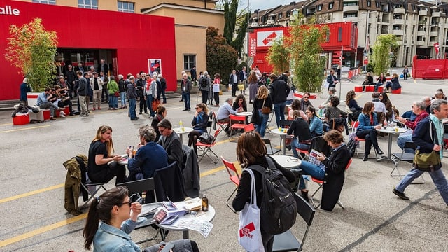 Menschen sitzen draussen auf Stühlen. Menschen sitzen draussen auf Stühlen.