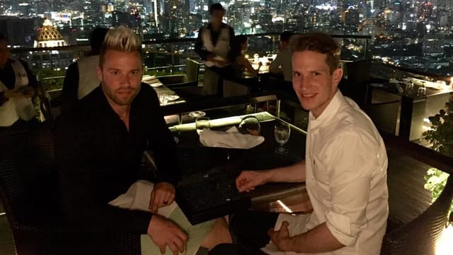 Jonny Fischer und Michi Angehrn sitzen an einem Tisch und lachen in die Kamera. Jonny Fischer und Michi Angehrn sitzen an einem Tisch und lachen in die Kamera.