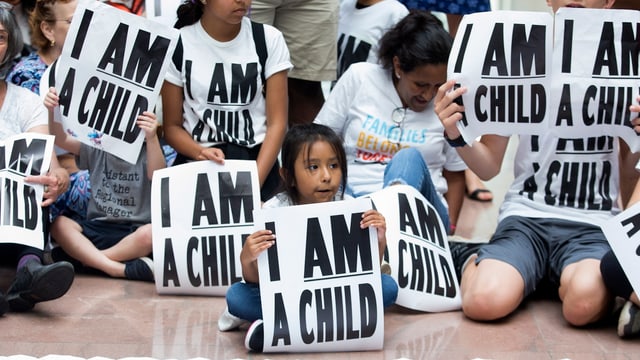 Ein Kind mit einem Schild «I am a child» Ein Kind mit einem Schild «I am a child»