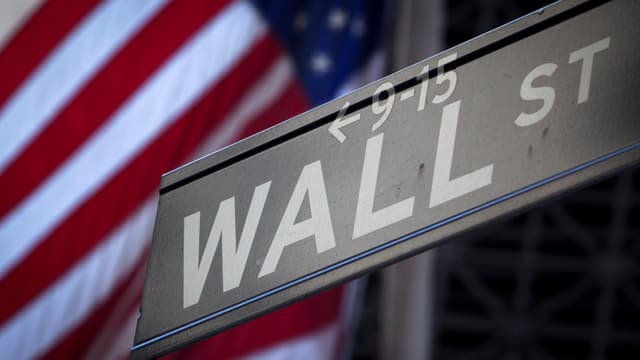 Wall Street-Strassenschild vor US-Flagge Wall Street-Strassenschild vor US-Flagge