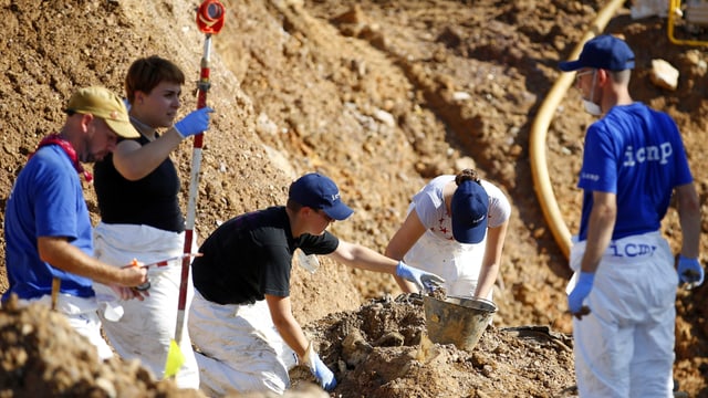 Forensiker durchsuchen Massengrab Forensiker durchsuchen Massengrab