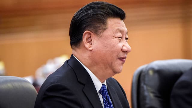 Chinas Staatspräsident Xi Jinping auf einem Sessel sitzend, seitliche Aufnahme