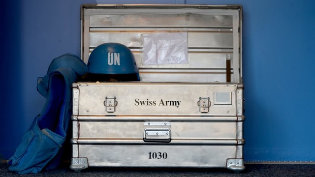UN-Blauhelm und ein Schweizer Armeekoffer UN-Blauhelm und ein Schweizer Armeekoffer