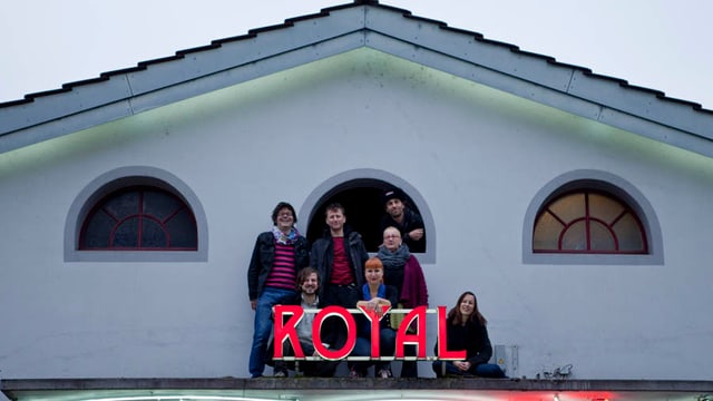 Menschen auf einem Dach mit dem Schriftzug Royal Menschen auf einem Dach mit dem Schriftzug Royal