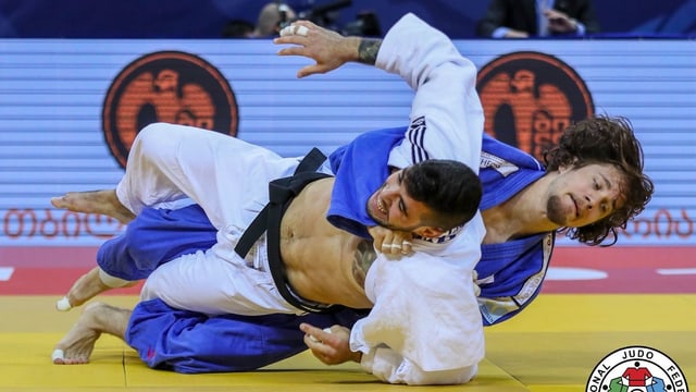 Zwei Judoka ringen auf einer Matte Zwei Judoka ringen auf einer Matte