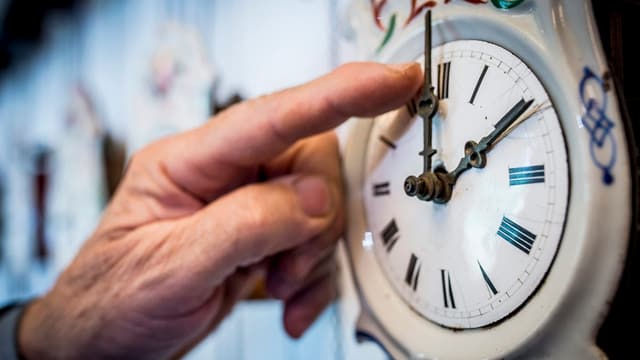 Jemand stellt die Uhr um. Jemand stellt die Uhr um.