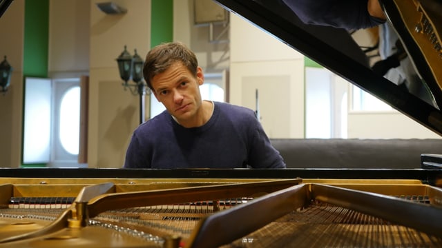 Ein Mann sitzt an einem Steinway-Konzertflügel und schaut dumm in die Kamera. Ein Mann sitzt an einem Steinway-Konzertflügel und schaut dumm in die Kamera.