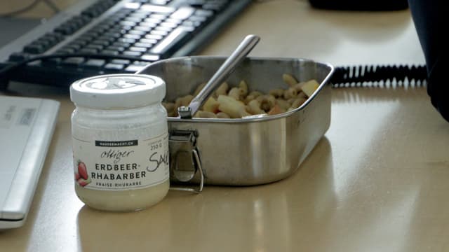 Ein Aluminium-Behälter mit Essen drin. Daneben steht ein Glas mit Salatsauce. Ein Aluminium-Behälter mit Essen drin. Daneben steht ein Glas mit Salatsauce.