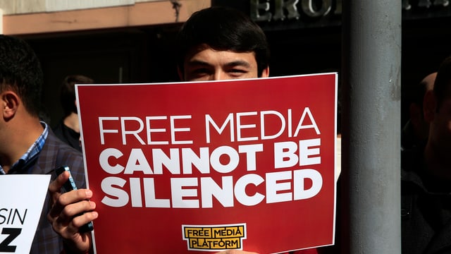 Symbolbild: Ein Mann hält ein Schild hoch, darauf heisst es: Freie Medien können nicht zum Schweigen gebracht werden. Symbolbild: Ein Mann hält ein Schild hoch, darauf heisst es: Freie Medien können nicht zum Schweigen gebracht werden.