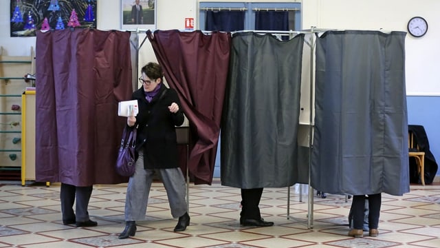 Vier Vorhänge als Wahlkabine, dahinter sieht man Füsse. Eine Frau kommt grade raus. Vier Vorhänge als Wahlkabine, dahinter sieht man Füsse. Eine Frau kommt grade raus.