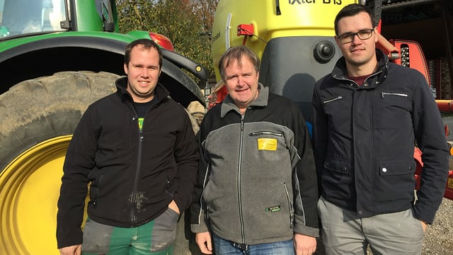 Drei Männer vor einem Traktor Drei Männer vor einem Traktor