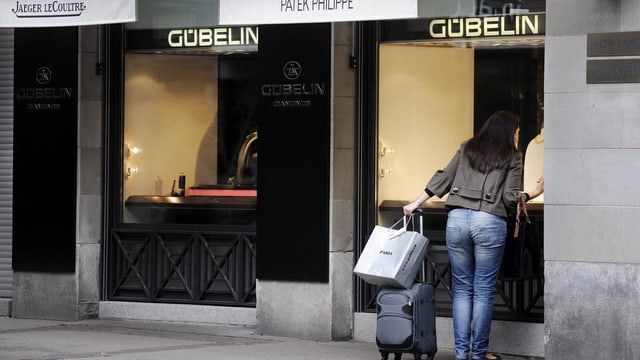 Eine Frau schaut in ein Schaufenster eines Schmuck-und Uhrengeschäftes in Zürich. Eine Frau schaut in ein Schaufenster eines Schmuck-und Uhrengeschäftes in Zürich.